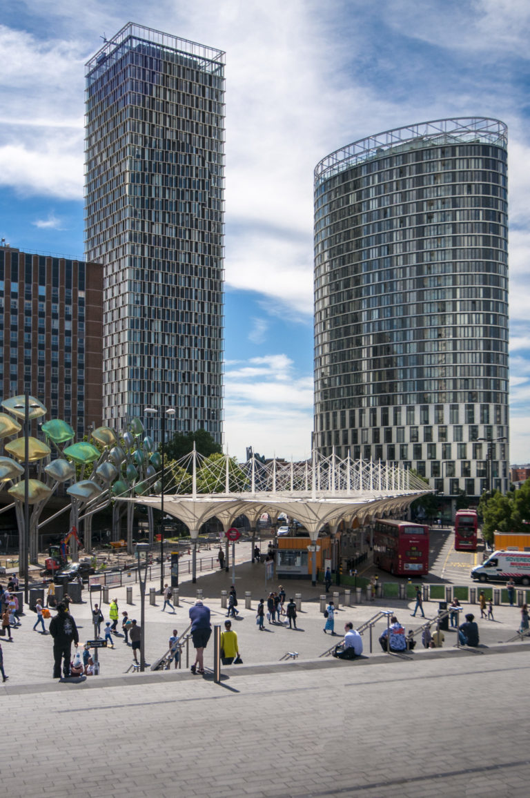 Two large glass office buildings near Stratford bus and train station London. People sitting on steps in the fourground.Suffolk Photographer | London Construction Photographer | David Chatfield